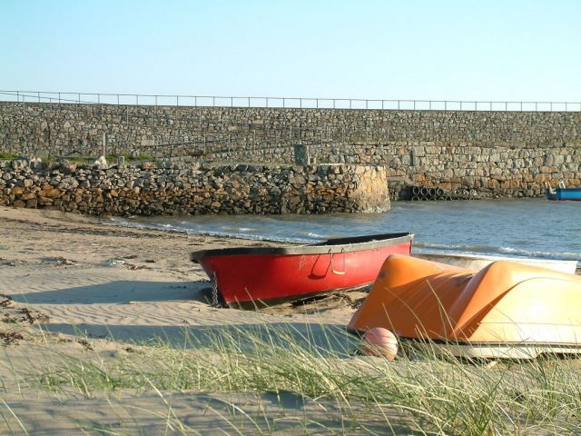 A view of the beach at Trefor with boats and jetty Llŷn Peninsula