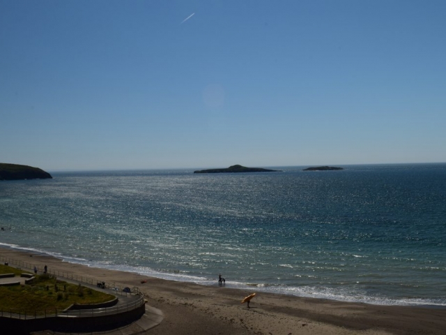 View of Aberdaron beach with surfer and islands Llŷn Peninsula