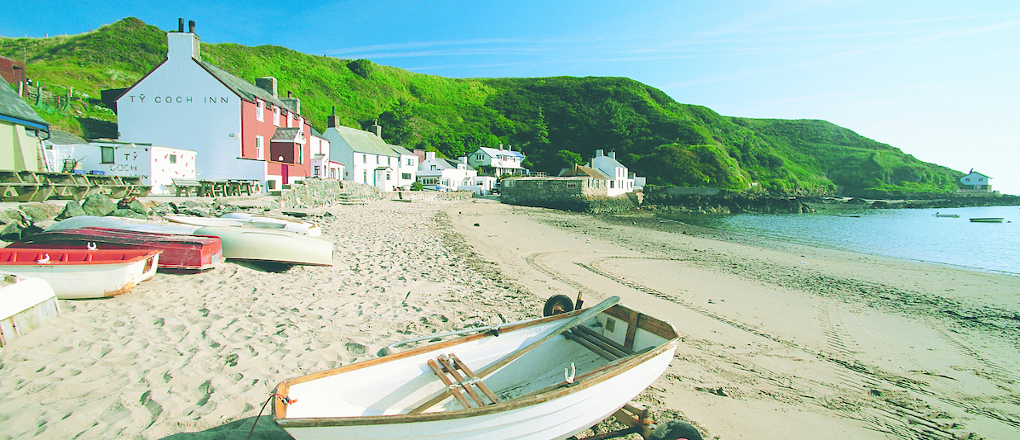 A view of boats and Ty Coch Inn at Porthdinllaen beach Morfa Nefyn Llyn Peninsula