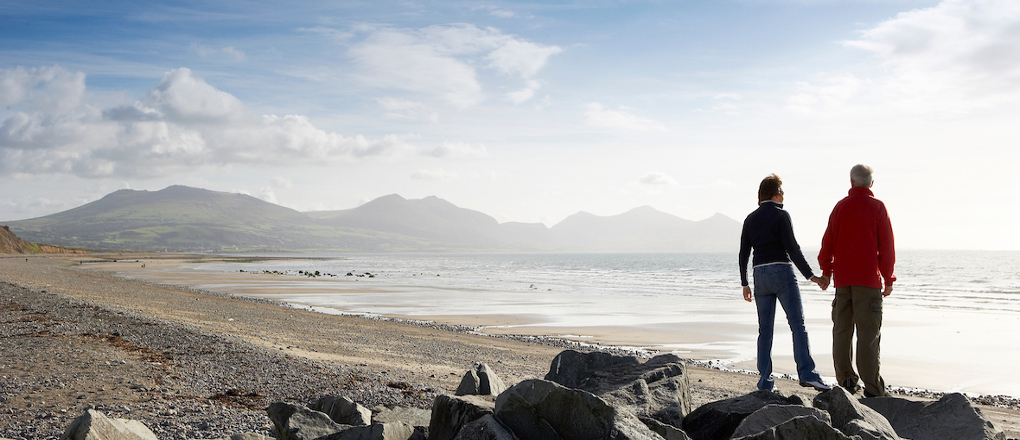 Couple overlooking the beach at Dinas Dinlle Caernarfon Llyn Peninsula North Wales