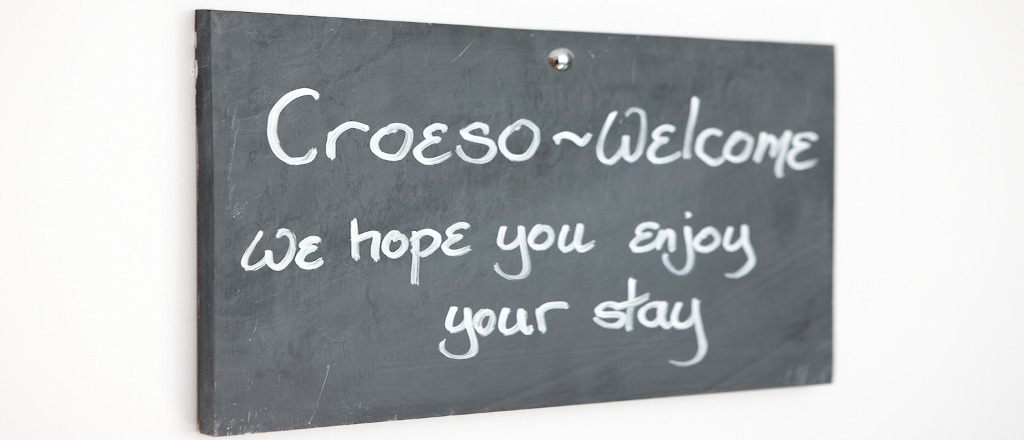 A slate sign with chalk writing saying croeso welcome