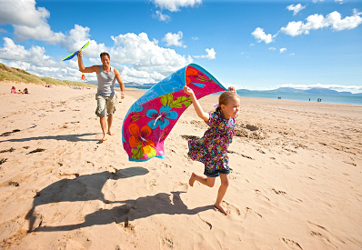 Girl flying kite on beach National Trust 50 Things List