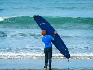 Young boy with surf board at beach